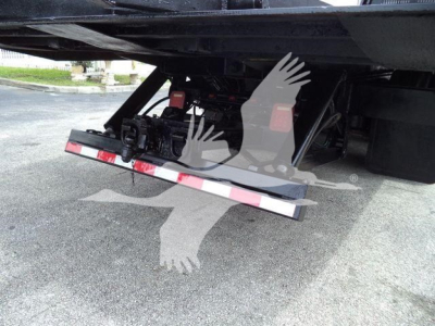Freightliner M2 106 roll-off truck undercarriage showing tailgate and hydraulic components.