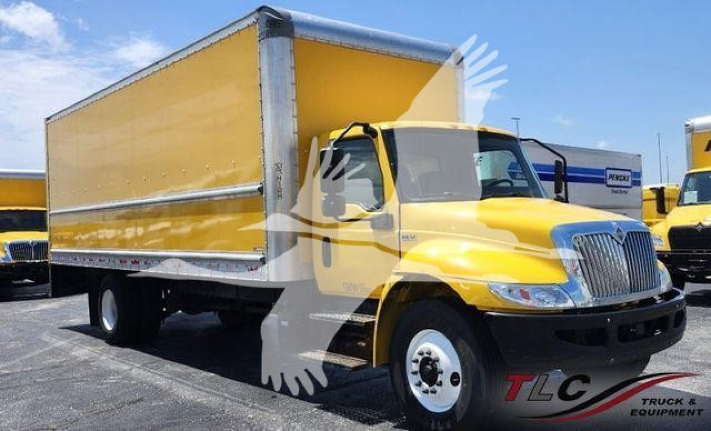 Box truck with yellow cab and large yellow box body, International logo on grille, front view at an outdoor lot.