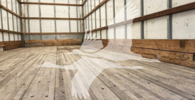 Interior of a truck trailer with empty wooden floor and metal walls.