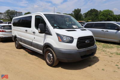 Ford Transit 350 van in a parking lot viewed from front-left angle showing cargo van body and grille.