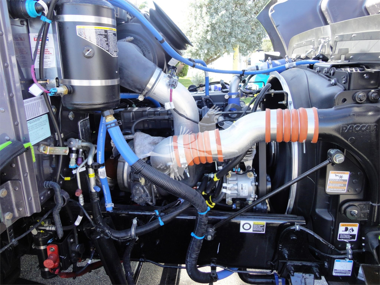 Engine bay of a 2022 Peterbilt 337 rollback truck showing intercooler hoses and air intake components.