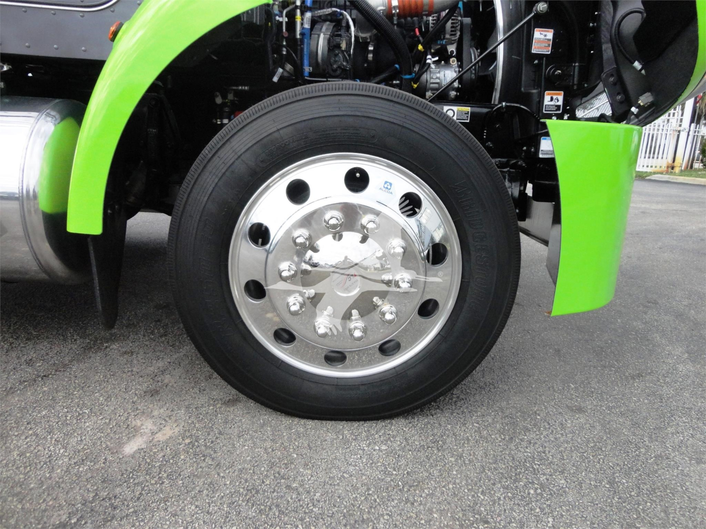 Peterbilt 337 front wheel and green fender showing chrome hub and tire