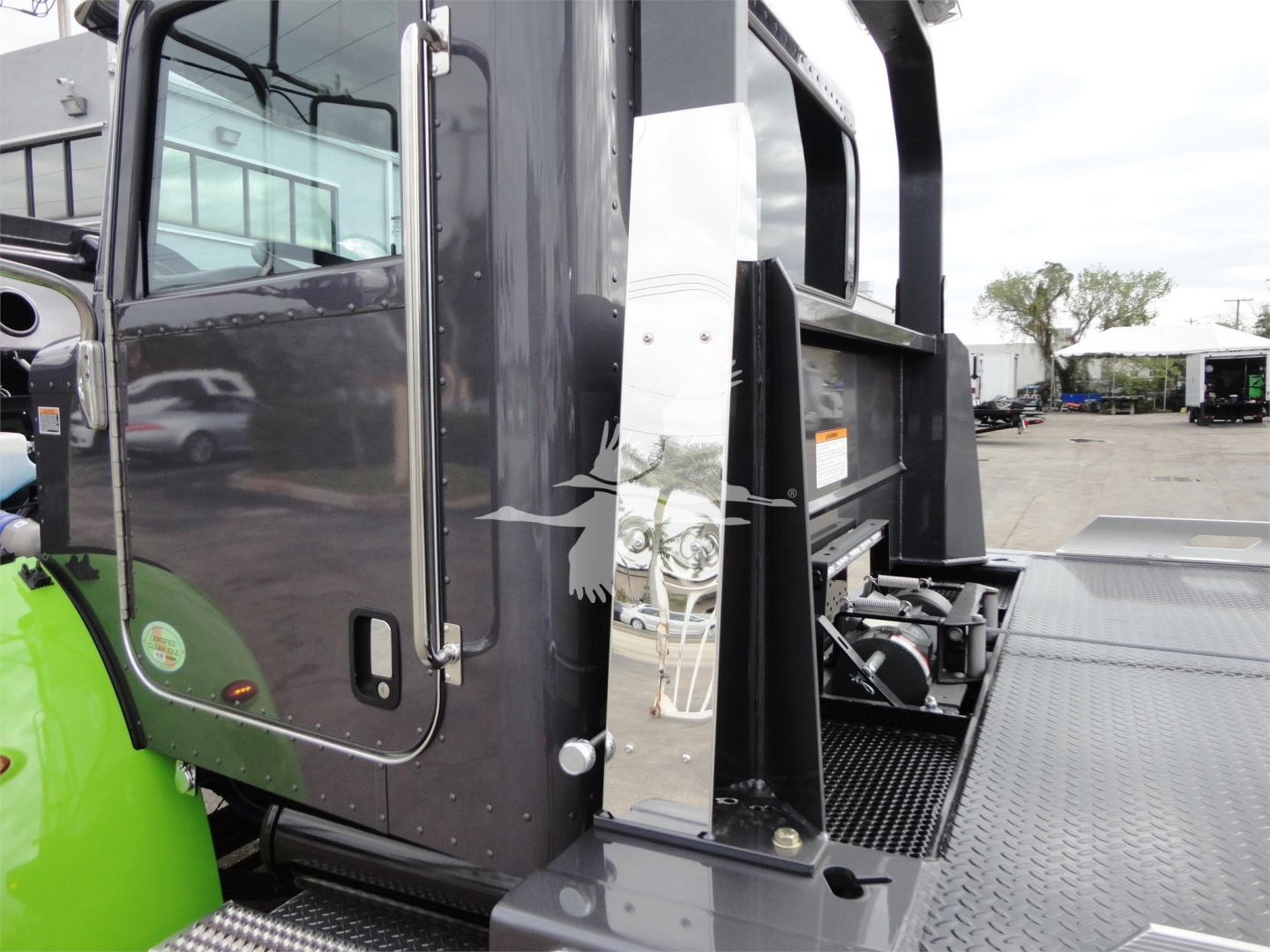 Peterbilt 337 rollback truck cab with metal platform and side step, black cab with green wheel guard visible