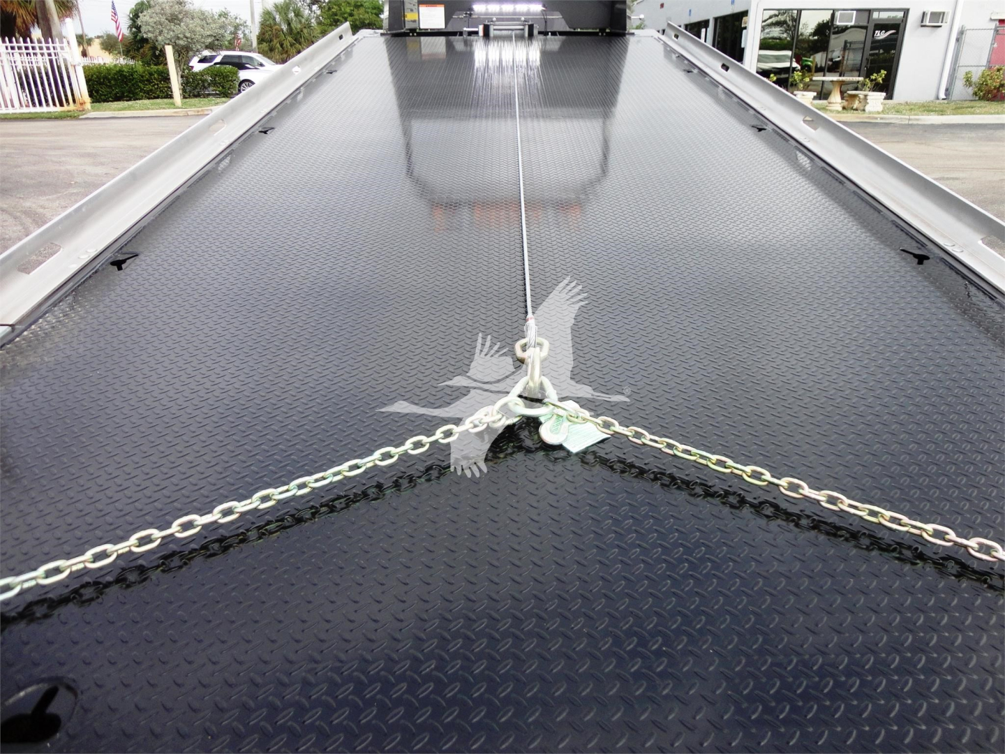 Peterbilt 337 rollback truck deck showing diamond plate steel surface and tied chains at the front center.