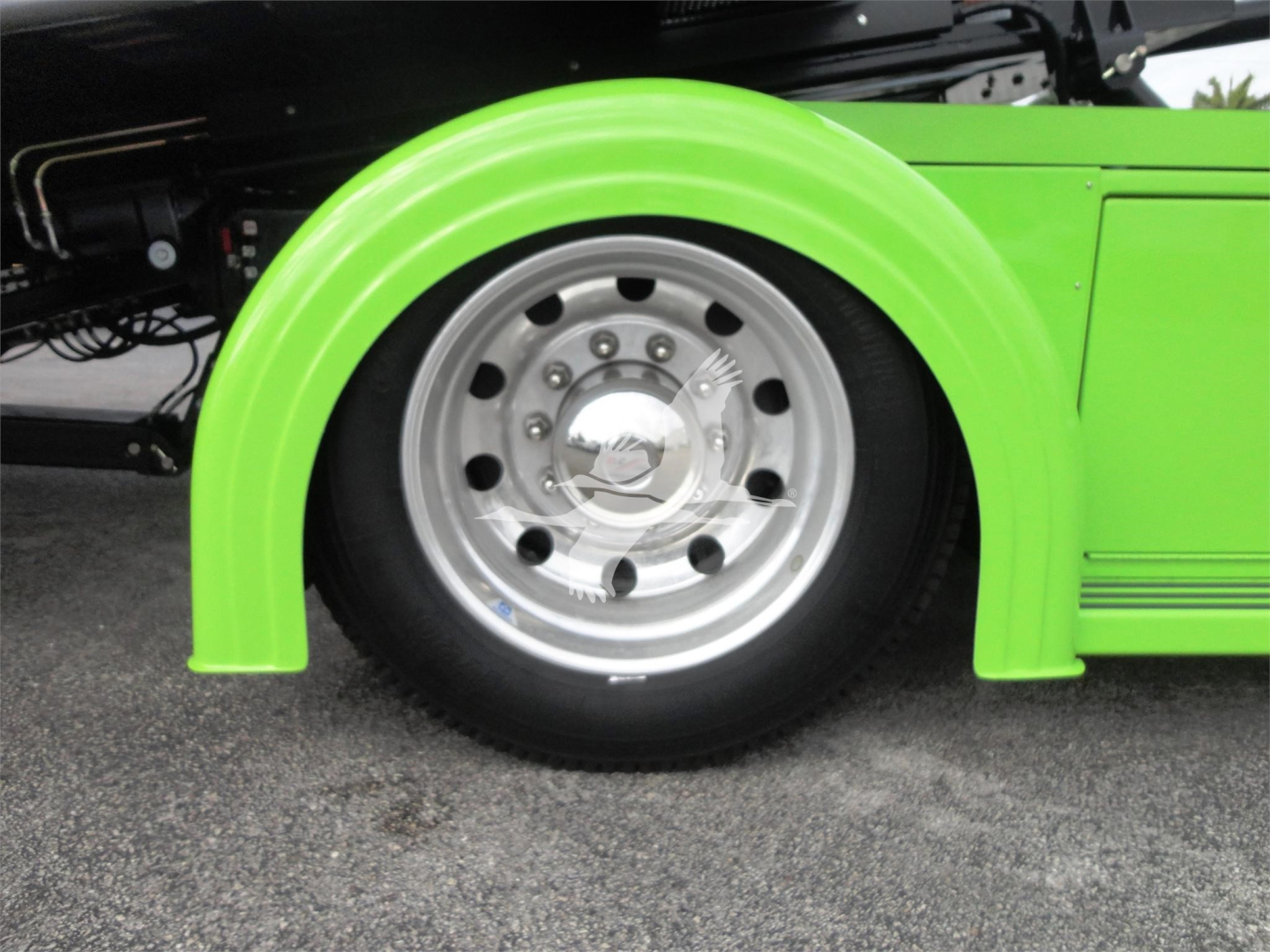 Green Peterbilt 337 rollback truck front wheel and fender with polished chrome wheel.