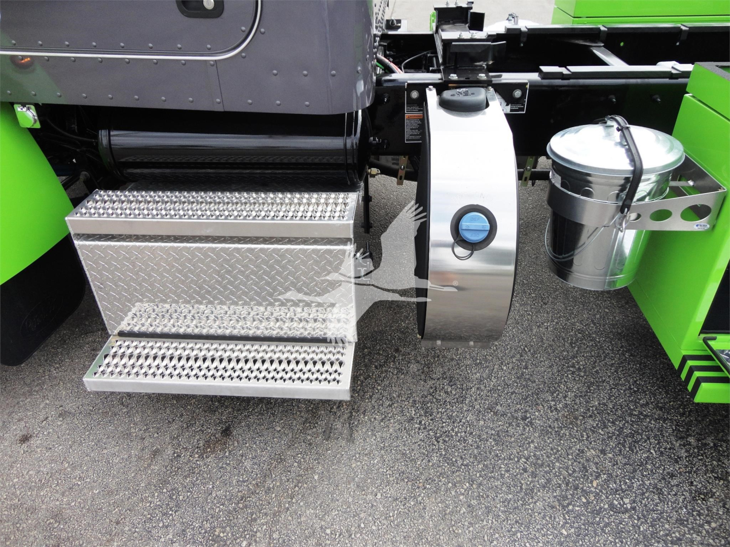 Peterbilt 337 rollback truck side with chrome fuel tank, diamond-plate step, and bright green bodywork.