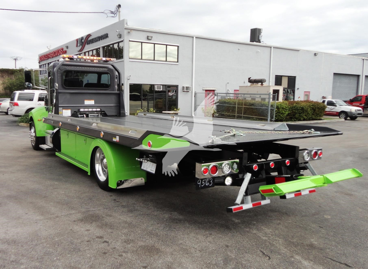 2022 Peterbilt 337 rollback truck shown from rear-left side with green paint and flatbed.