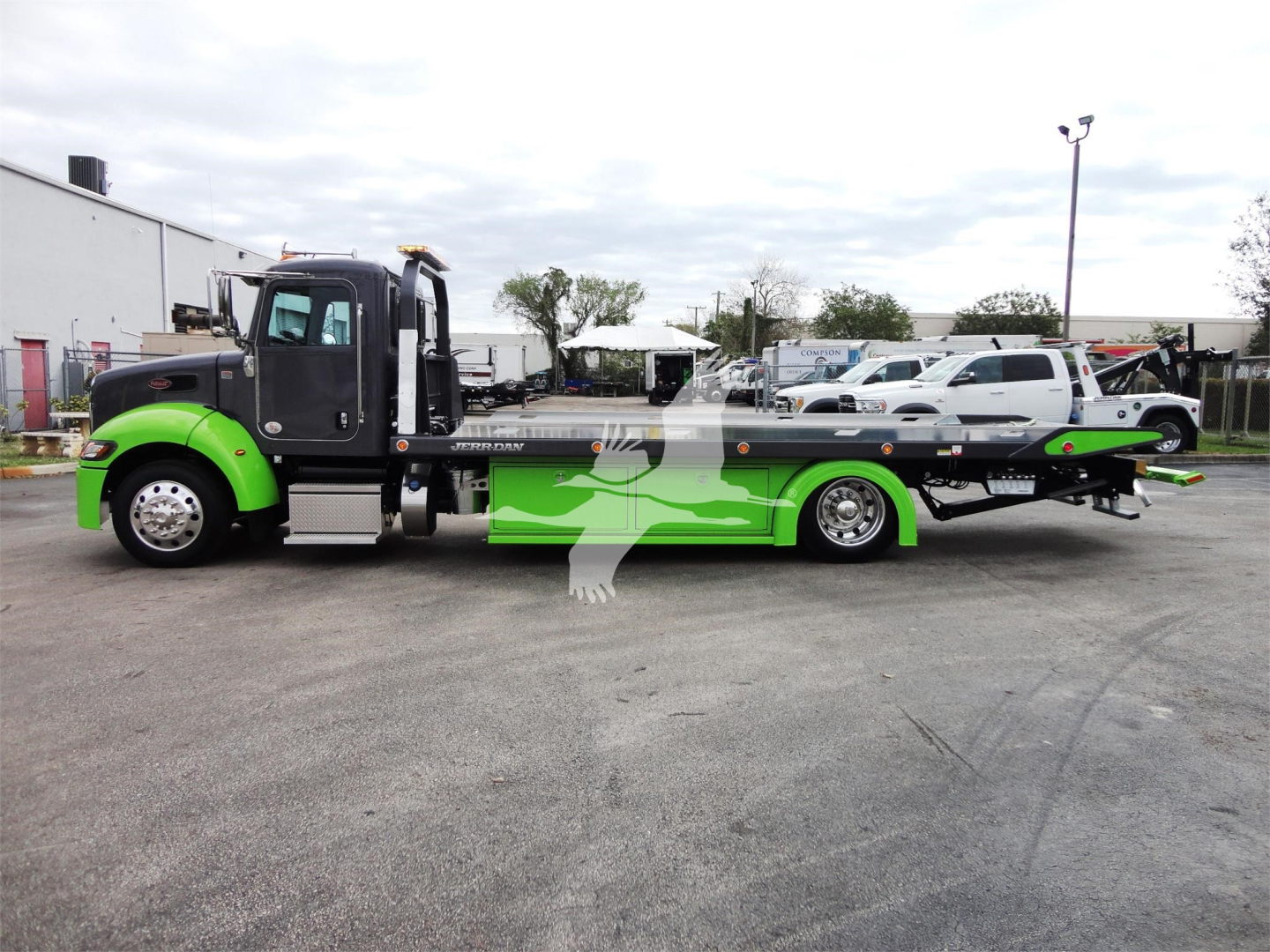 Peterbilt 337 rollback tow truck side view in green and black color scheme showing flatbed.