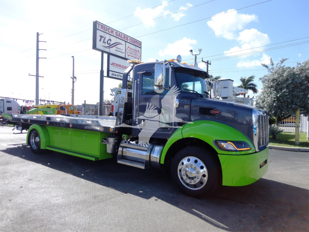 Peterbilt 337 rollback tow truck profile with black cab and bright green lower body, stock number J56626 visible at dealership lot.