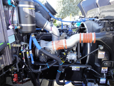Engine bay of a 2022 Peterbilt 337 rollback truck showing intercooler hoses and air intake components.