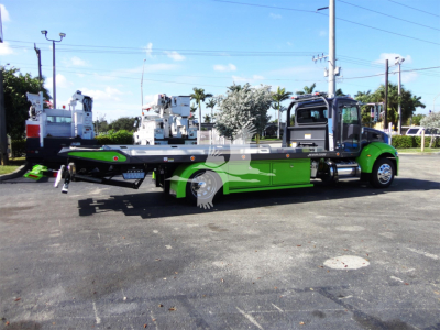 2022 Peterbilt 337 rollback truck side view showing flatbed with green accents and equipment on bed.