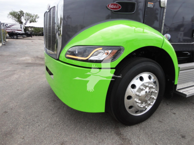 Peterbilt 337 truck front fender and wheel showing bright green paint and headlight with chrome hubcap.