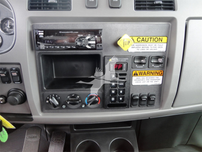 Peterbilt 337 dashboard/center console with radio, cup holders, climate controls and warning labels visible