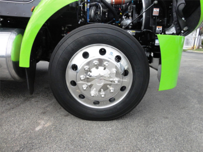 Peterbilt 337 front wheel and green fender showing chrome hub and tire