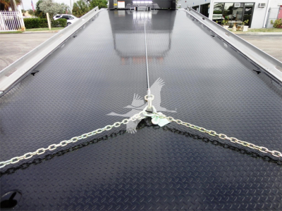 Peterbilt 337 rollback truck deck showing diamond plate steel surface and tied chains at the front center.