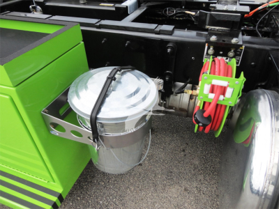 Peterbilt 337 rollback truck showing silver metal oil canister mounted near green toolbox and red hose reel.