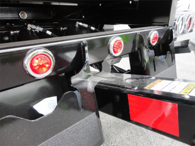 Peterbilt 337 rollback trailer hitch area showing rear lights and reflective red/white striping.