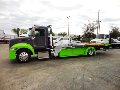 Truck image: 2022 Peterbilt 337 rollback with lime green accent on bumper and lowbed, side view showing cab and tow deck