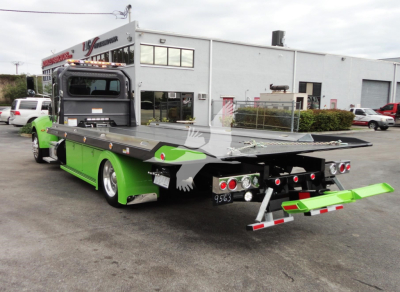 2022 Peterbilt 337 rollback truck shown from rear-left side with green paint and flatbed.