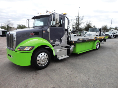 Peterbilt 337 rollback truck with bright green accents and gray cab, side view showing flatbed and wheels.