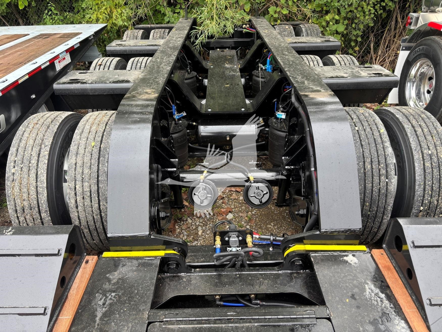 Fontaine 55MX lowboy trailer chassis view showing dual rear bogies and hydraulic coupling area with wheels and frame.
