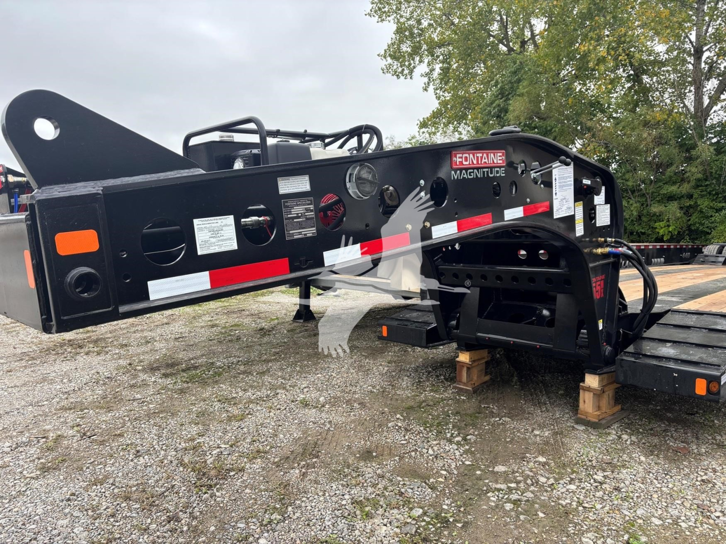 Fontaine 55MX lowboy trailer with black frame and white/red reflective decals showing Fontaine Magnitude logo on side.
