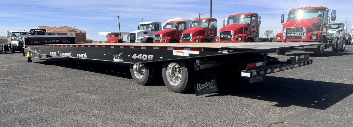 2026 Landoll 440B-53 40 Ton Slide Axle trailer showing long lowboy with red trucks in background and branding 'Landoll' on side
