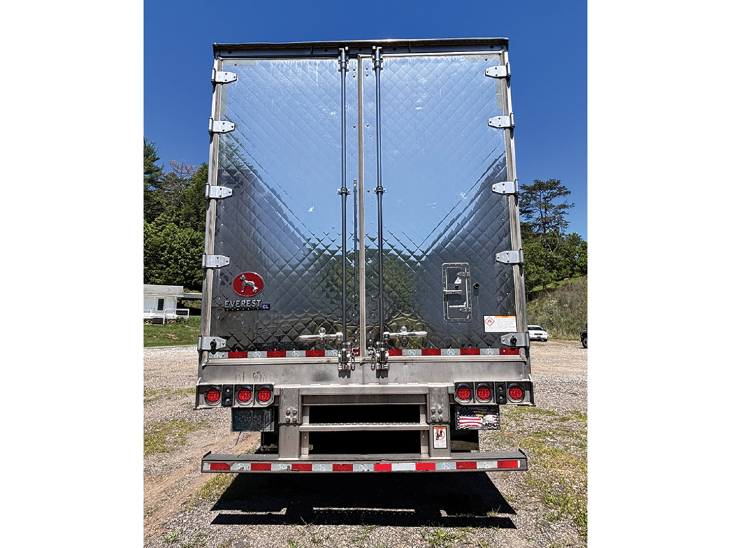 Rear view of a 2022 Great Dane Everest CL reefer trailer showing diamond plate reflective back doors and bumper with taillights and safety decals.