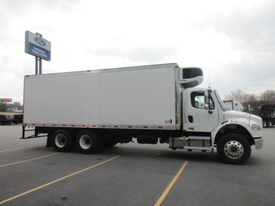 Freightliner M2 106 Plus refrigerated truck side view with cargo box and aerodynamic cap on cab.