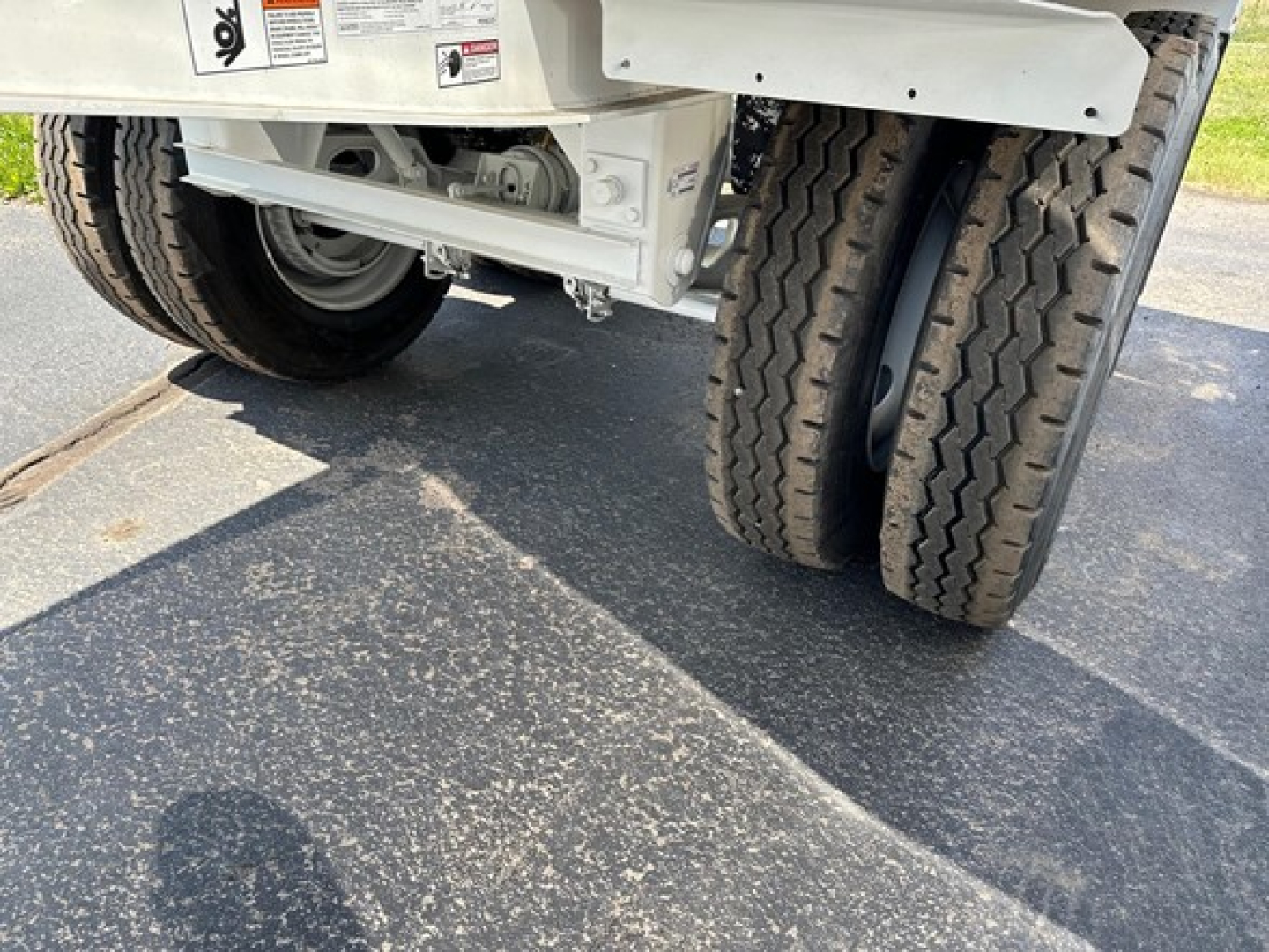 Trailer undercarriage showing dual rear wheels and suspension on new dump trailer.