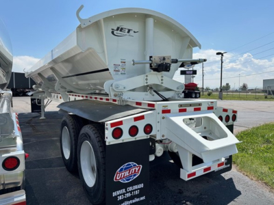 Jet Jet side dump trailer showing rear view with dual rear axles, white paint, and Utility trailer logo.