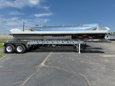 Trailer side-dump semi-trailer with aluminum dump body and dual rear axles. Cargo area label AMERICA! on white and gray surface; tandem wheels and landing gear visible.