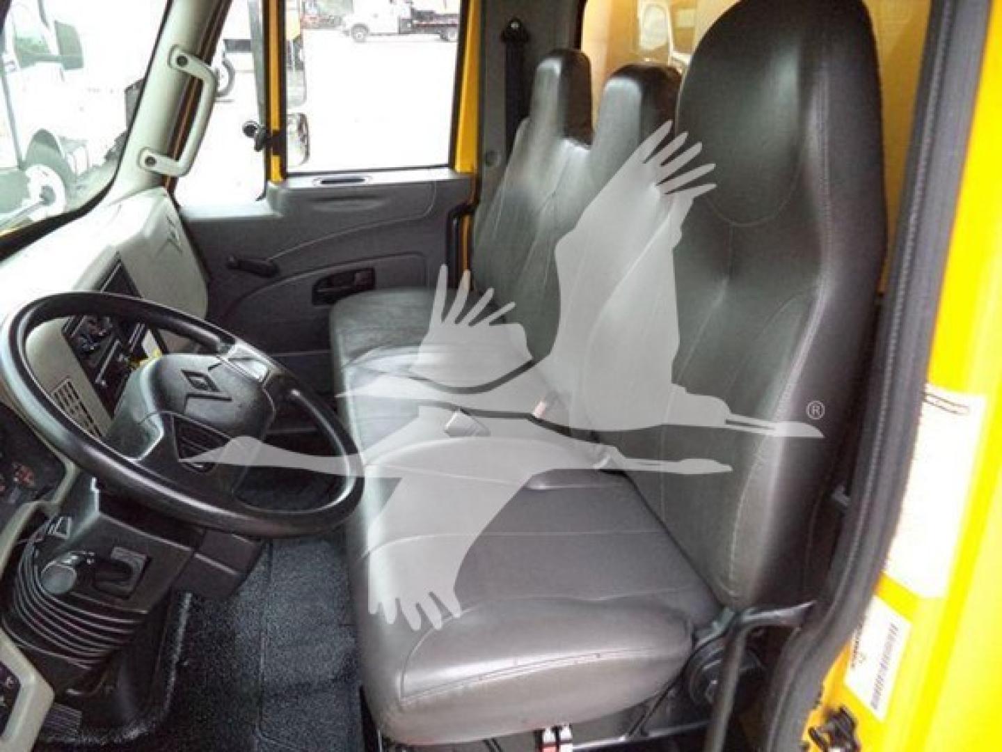 Cab interior of a 2019 International Durastar 4300 showing steering wheel, driver seat, passenger seat, and door; no legible text visible.