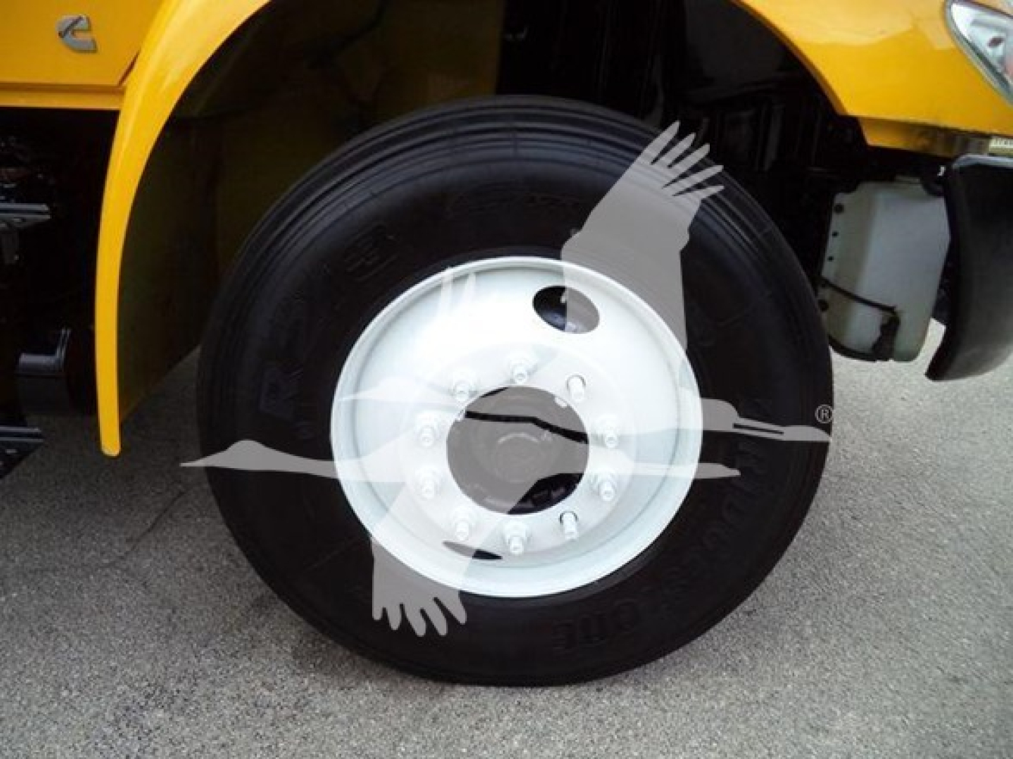 Truck wheel close-up on a yellow 2019 International Durastar 4300 chassis showing black tire and white steel wheel with center hub.