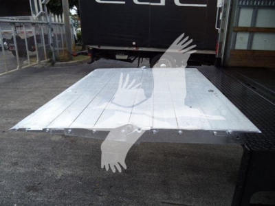 Flatbed truck bed shown with metal platform and riveted edge bolts.