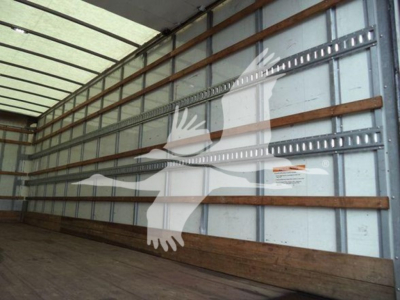 Truck box interior showing metal side walls with wooden strapping and a white bird watermark.