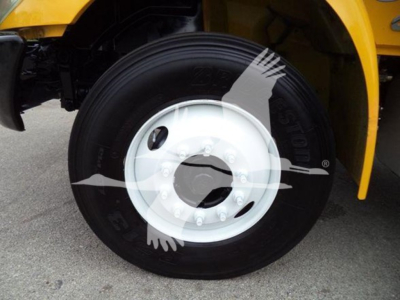 Truck wheel with white hub and black tire on a yellow International Durastar 4300; partial fender and body in background.
