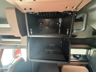 Mack PR64T76H truck cab interior showing open overhead storage compartments and dashboard area.