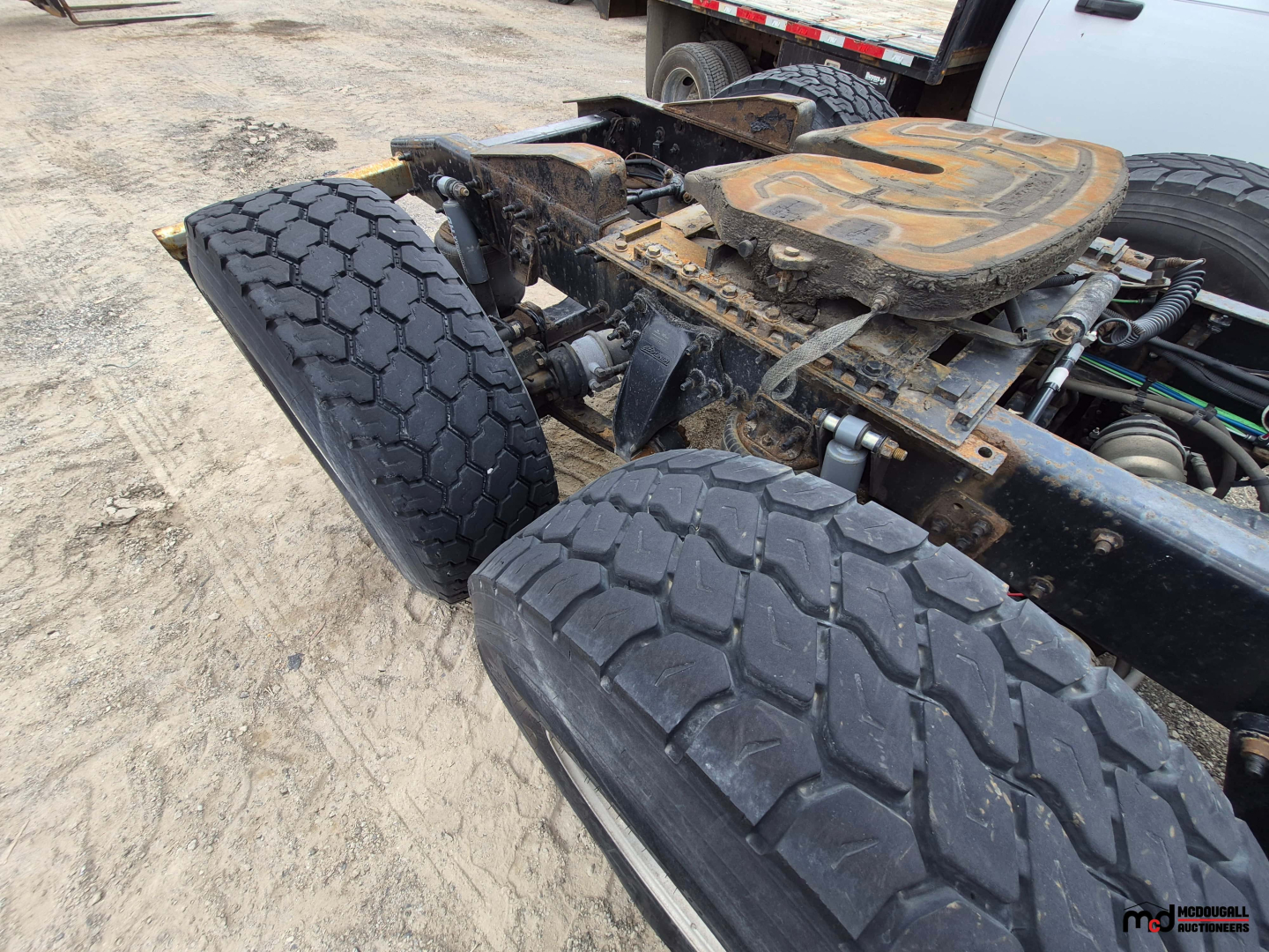 Truck chassis showing rear dual wheels and fifth wheel plate on a Freightliner Cascadia conv sleeper truck.