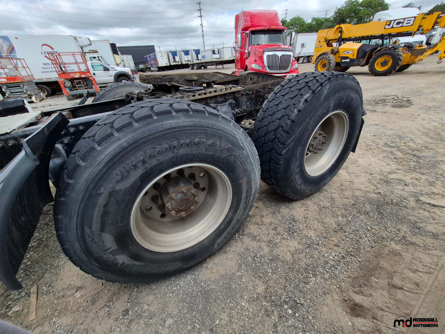 Freightliner Cascadia truck chassis showing dual rear axles with heavy-duty tires and wheels, bare frame and drivetrain components visible.