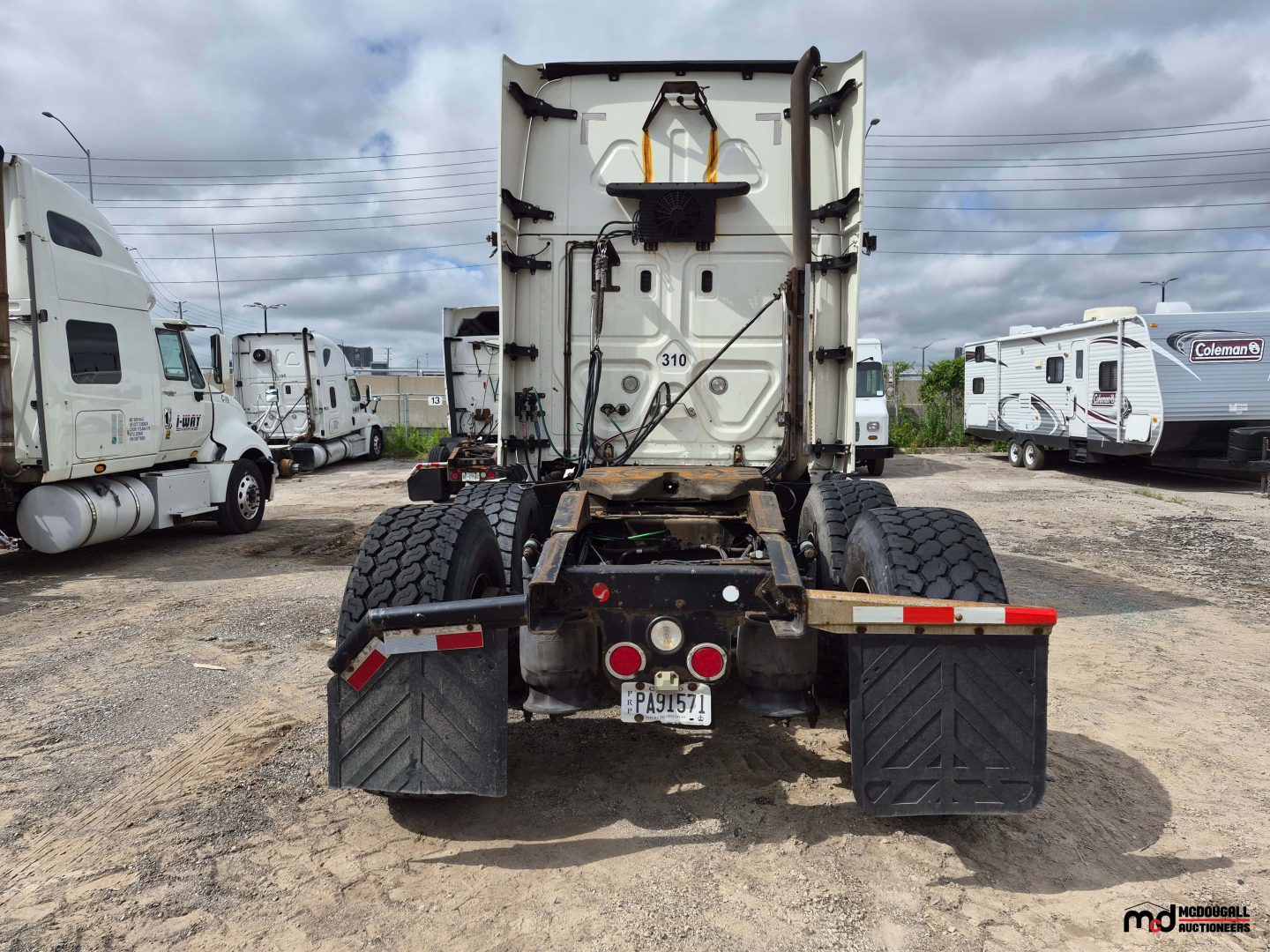 Freightliner Cascadia rear view showing fifth-wheel area, dual rear axles, and mud flaps.