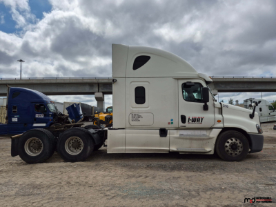 Truck side view showing a white Freightliner Cascadia with sleeper cab, J-Way logo, and VIN/emblem areas visible on door; no other readable text discernible.