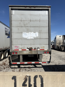 Rear view of a 2014 Wabash roll door trailer showing metal back door with hinges and taillights.