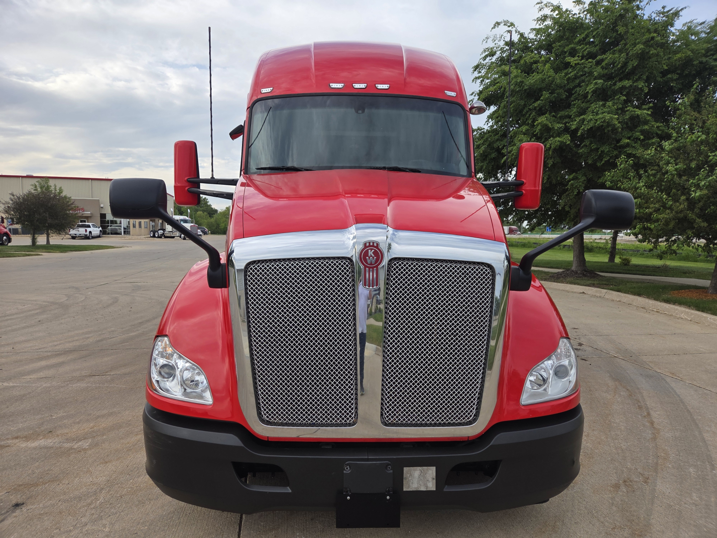 Kenworth T680 front view showing grille, headlights, and windshield with large side mirrors.