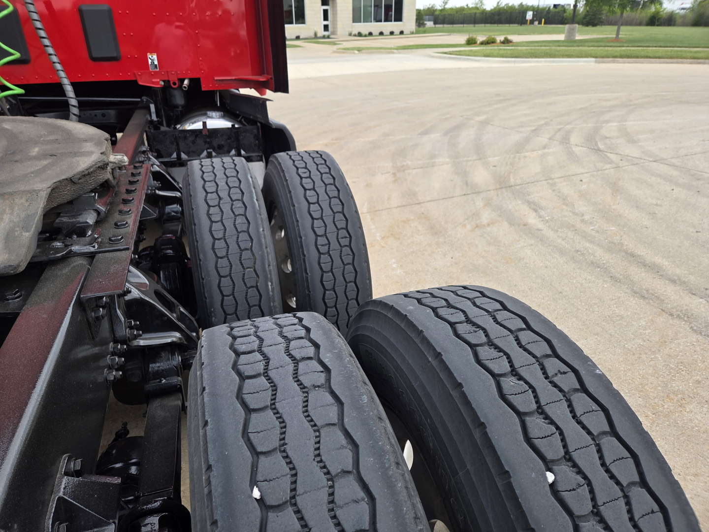 Kenworth T680 truck rear dual axle tires and chassis viewed from side perspective.