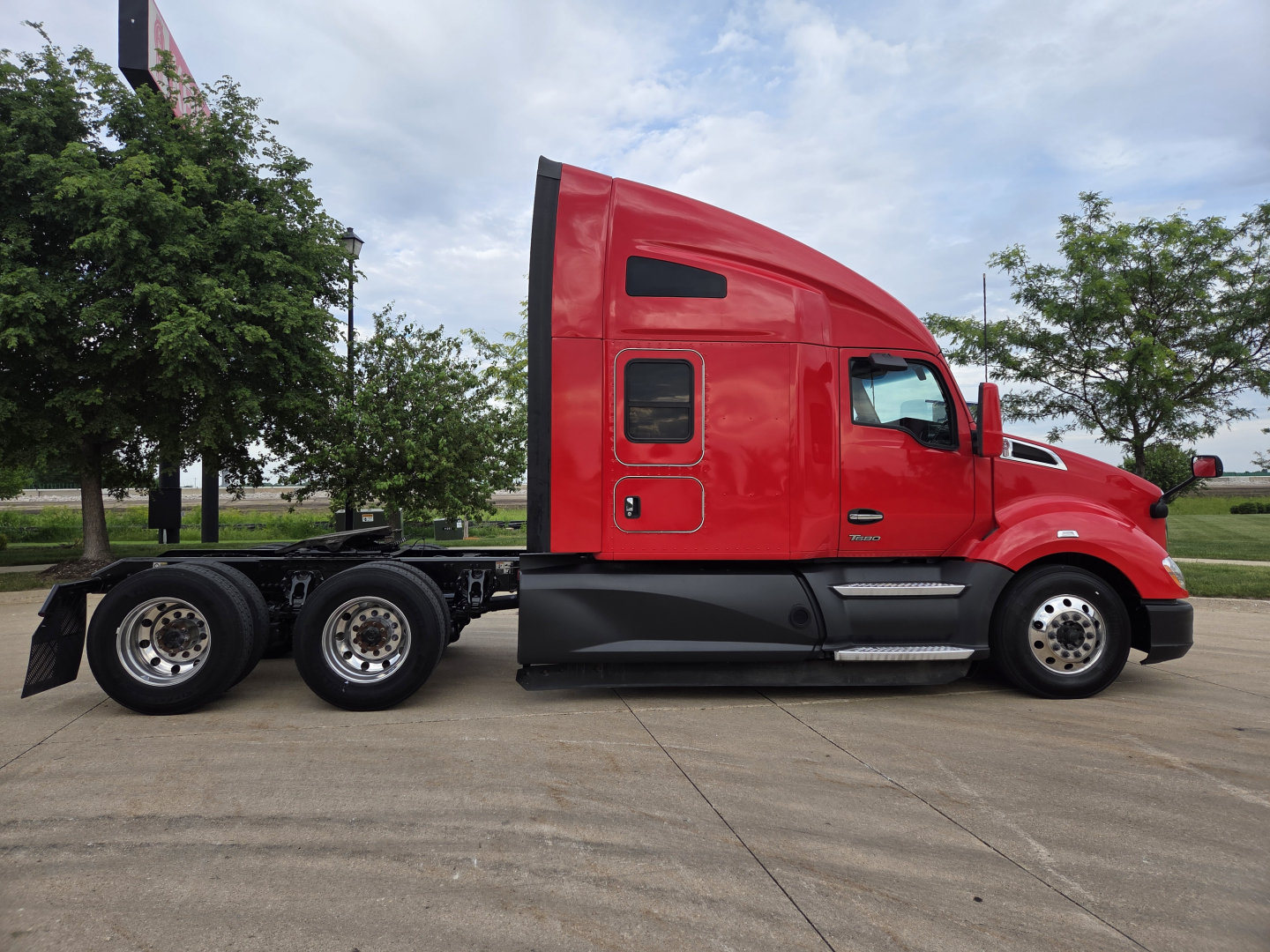 Kenworth T680 tractor unit in red, side profile view showing sleeper cab and dual rear axles.