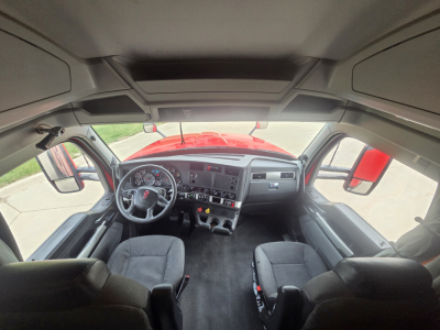 Kenworth T680 truck cabin interior from front view showing steering wheel, dashboard, and front seats.