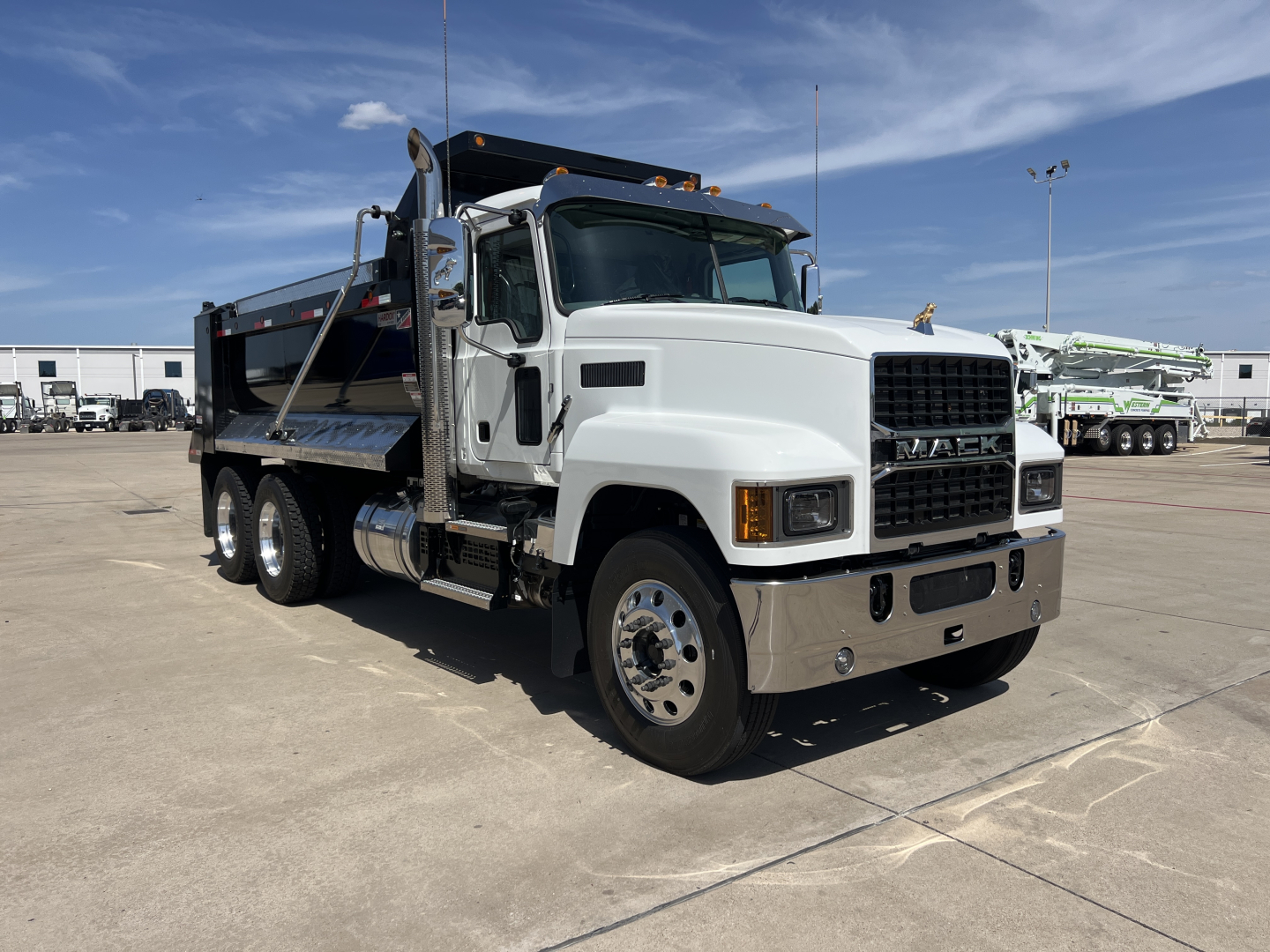 Dump truck in white and black Mack PI64 cab with dual rear wheels, side steps, and dump bed visible; Century 2027 model year with VIN 1M2PN4GC2VM022164 and stock 73250.
