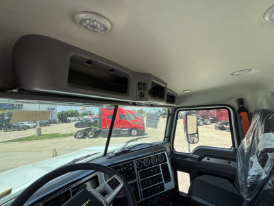 Mack PI64 truck cab interior showing dashboard, steering wheel, and overhead console.
