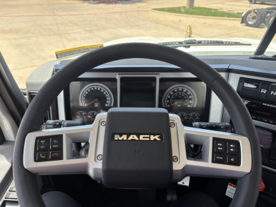 Mack PI64 truck cab interior showing steering wheel with Mack logo, instrument cluster, and control stalks.